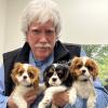 Kevin Fitzgerald holding three King Charles Spaniel puppies