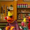 Sesame Street muppets and Alan Muraoka wearing party hats on Sesame Street