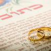 two gold rings on Hebrew ketubah