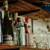alcohol bottles and empty glasses on a shelf