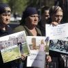 mothers of victims of the school siege walk to a court, holding portraits of their children, in Vladikavkaz, May 16, 2006. Prosecutors had called for the death penalty for Nur-Pasha Kulayev, who admitted participating in the attack on school in Beslan in 2004, but denied killing anybody. Posters read: “We demand justice!” (left) and “Kulayev and the like, be damned for all eternity!!!” (AP Photo/Sergei Grits)