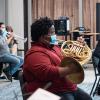 Covid-safe students wear masks with slits in them while playing their wind instruments