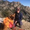 Emily Kibby with a brown dog in mountains