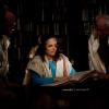 Female rabbi reading a text with two male colleagues standing on either side
