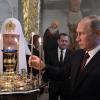 Russian President Vladimir Putin, accompanied by Patriarch of Russia Kirill and Prime Minister Dmitry Medvedev (in background), at a monastery outside Moscow in 2017.