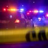 Crime scene tape and police cars with lights on