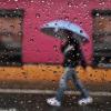 Person walking in rain with umbrella