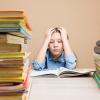 Child reading at table stacked with books