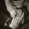 A baby holding a grandparent's hand