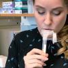 Camille Paige, a researcher at the BioFrontiers Institute, spits into a tube to demonstrate how SickStick works.