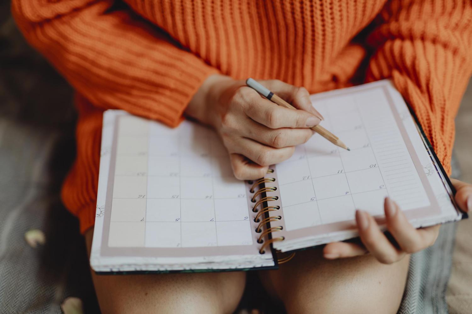 Young woman marking a date in her day planner