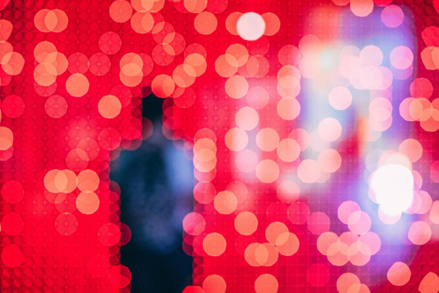 shadow of a person walking through pink faded lights