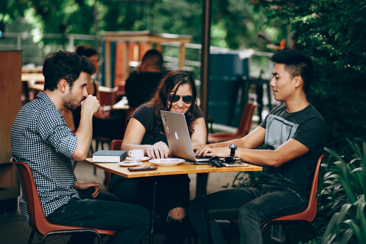people sitting at an outdoor computer cafe