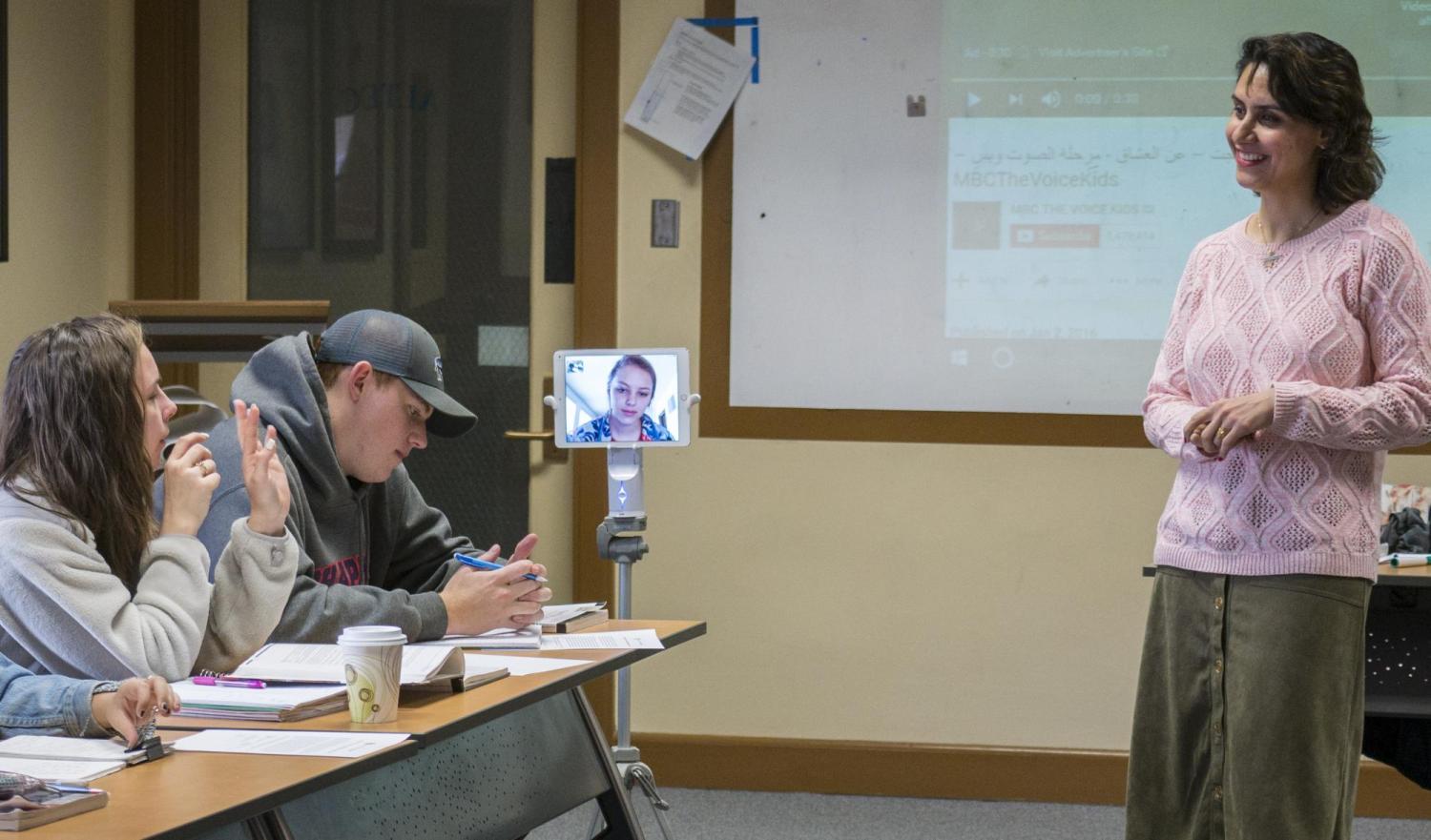 Students chatting with their instructor. One of the students appears on-screen on a Kubi device.