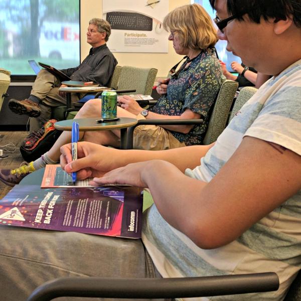 Austin Chau marking up magazine pages in a workshop on graphic design