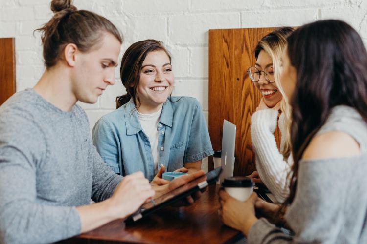 a group of adults chat at a table together