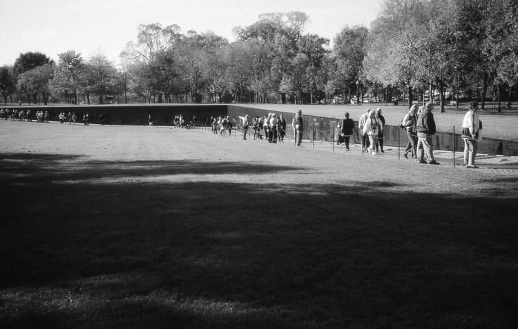 line of people walking across a greenway