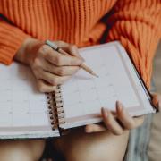 Young woman marking a date in her day planner