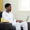 Student working on a laptop in his living room