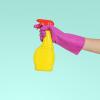 Person wearing rubber gloves using a spray bottle