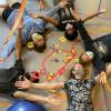 Students holding hands in a circle laying down