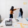 Two women working at a whiteboard during a board meeting