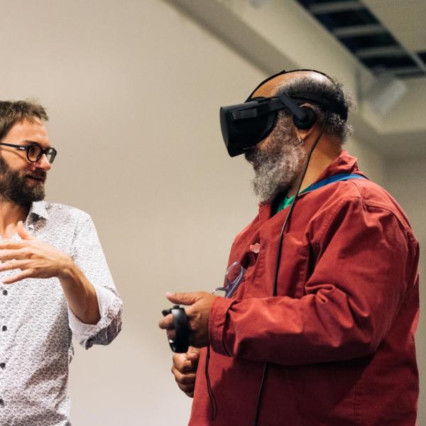 man with VR googles interacting with daniel leithinger with glasses