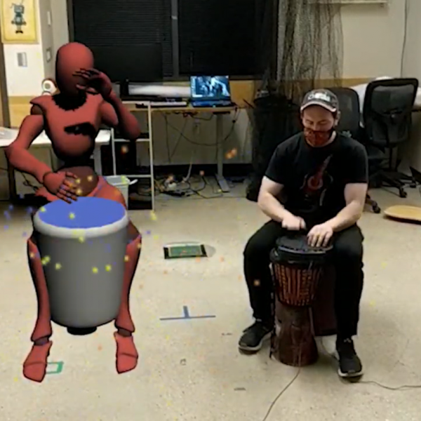 Virtual drummer avatar next to in-person drummer