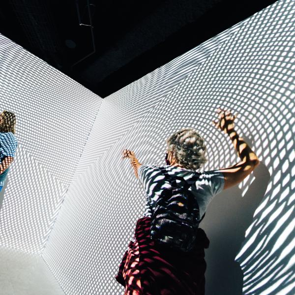 people dancing in front of black and white projection art