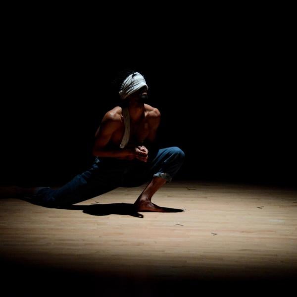 Jesús Muñoz dancing with a blindfold under a spotlight
