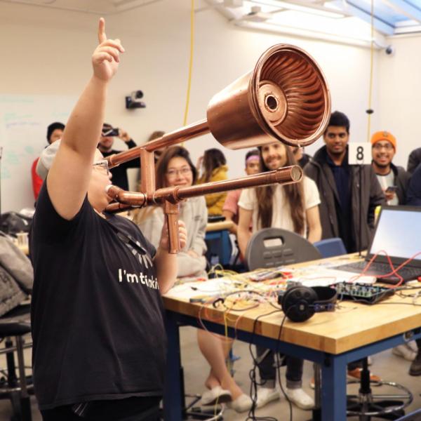 Ruhan Yang plays e-trombone in front of audience at Hackathon