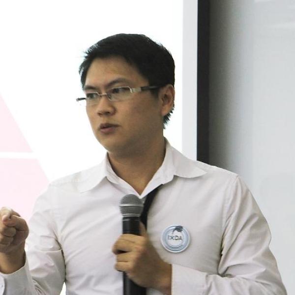 sheng kai tang giving a presentation in front of a projection screen