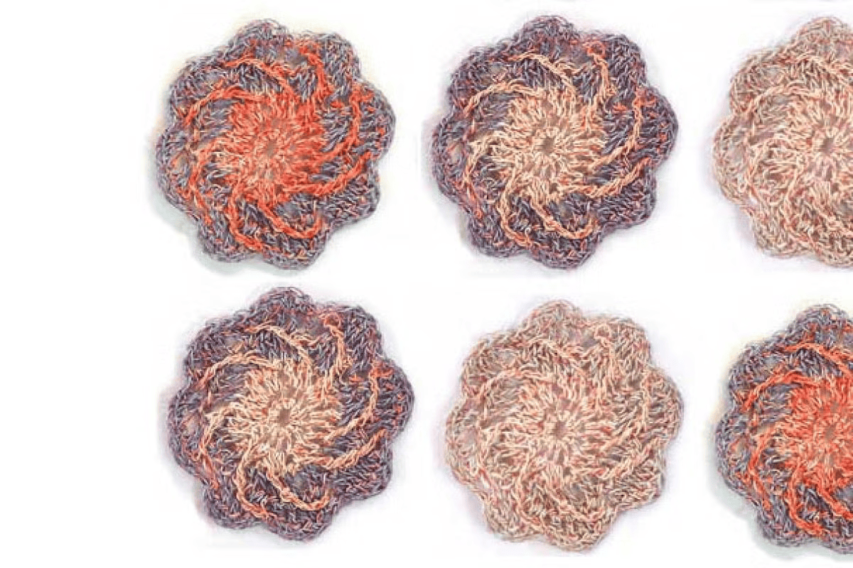 A set of 6 flower shaped woven items on a white background in orange and muted purple colors.