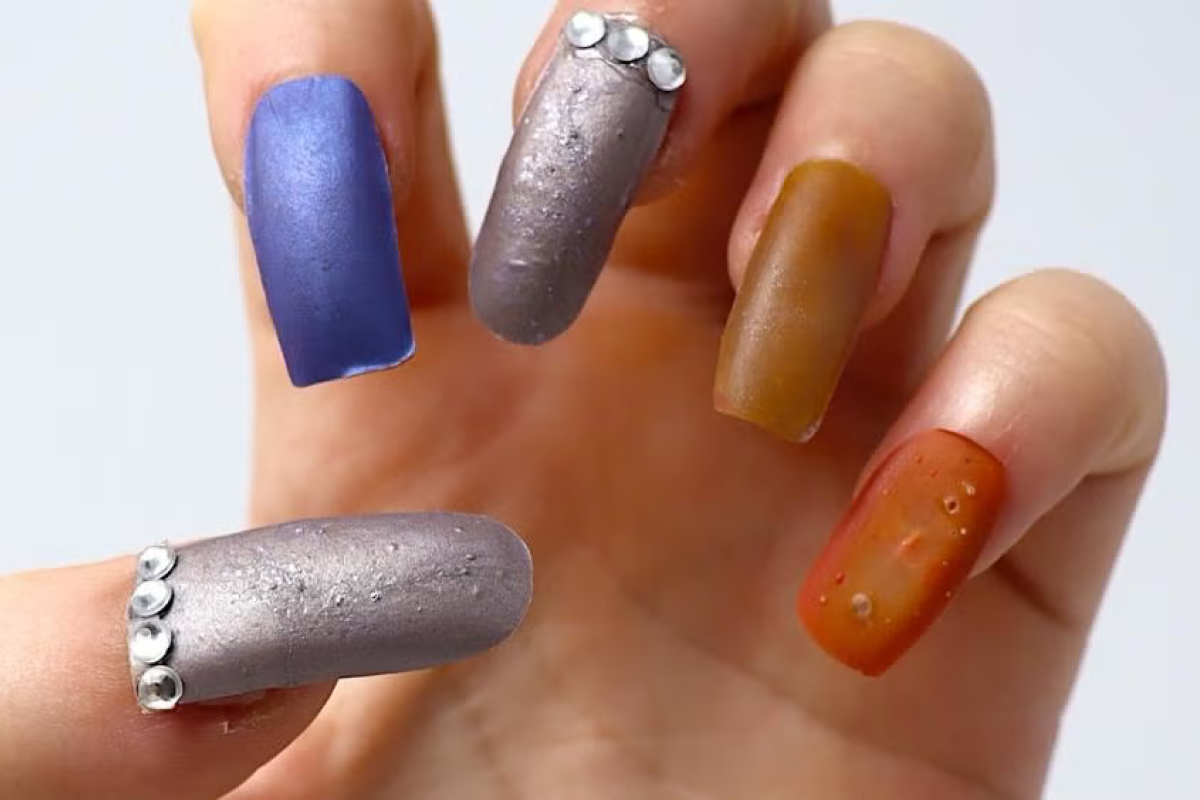 Hand positioned to show off a set of multicolored fake nails