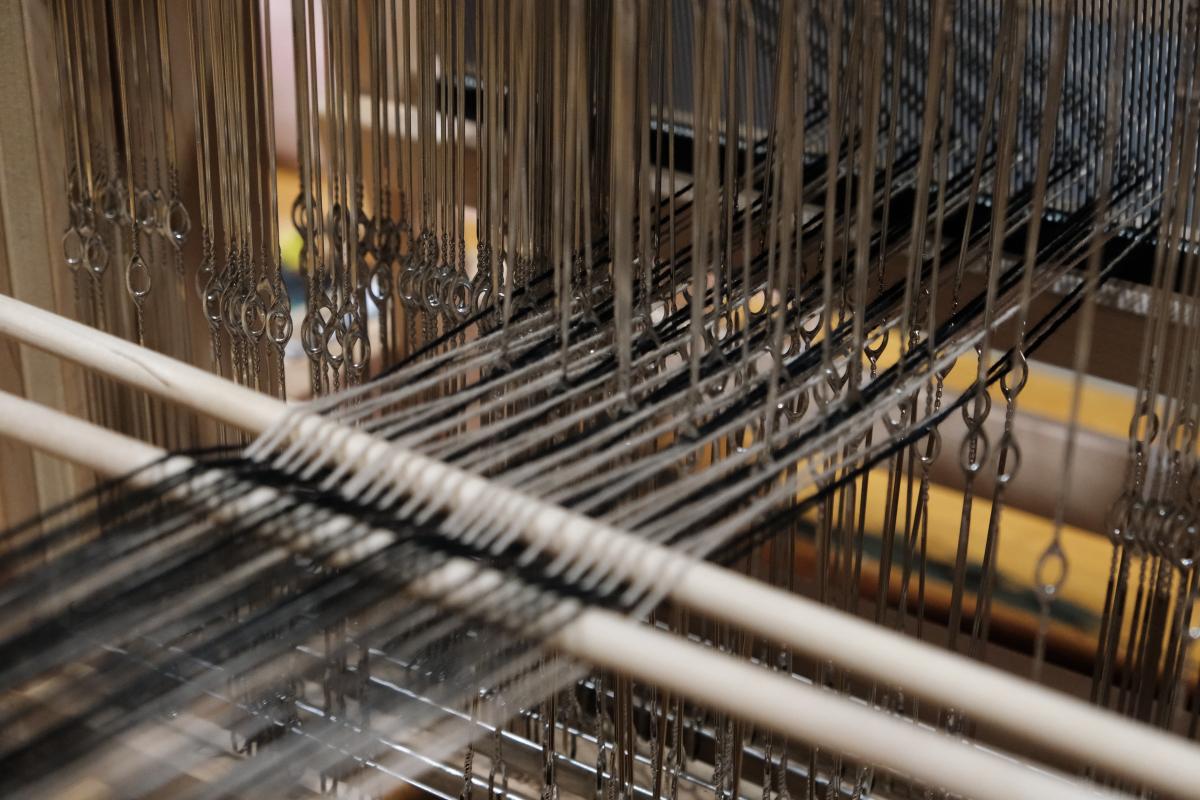Close up of a loom with threads on it