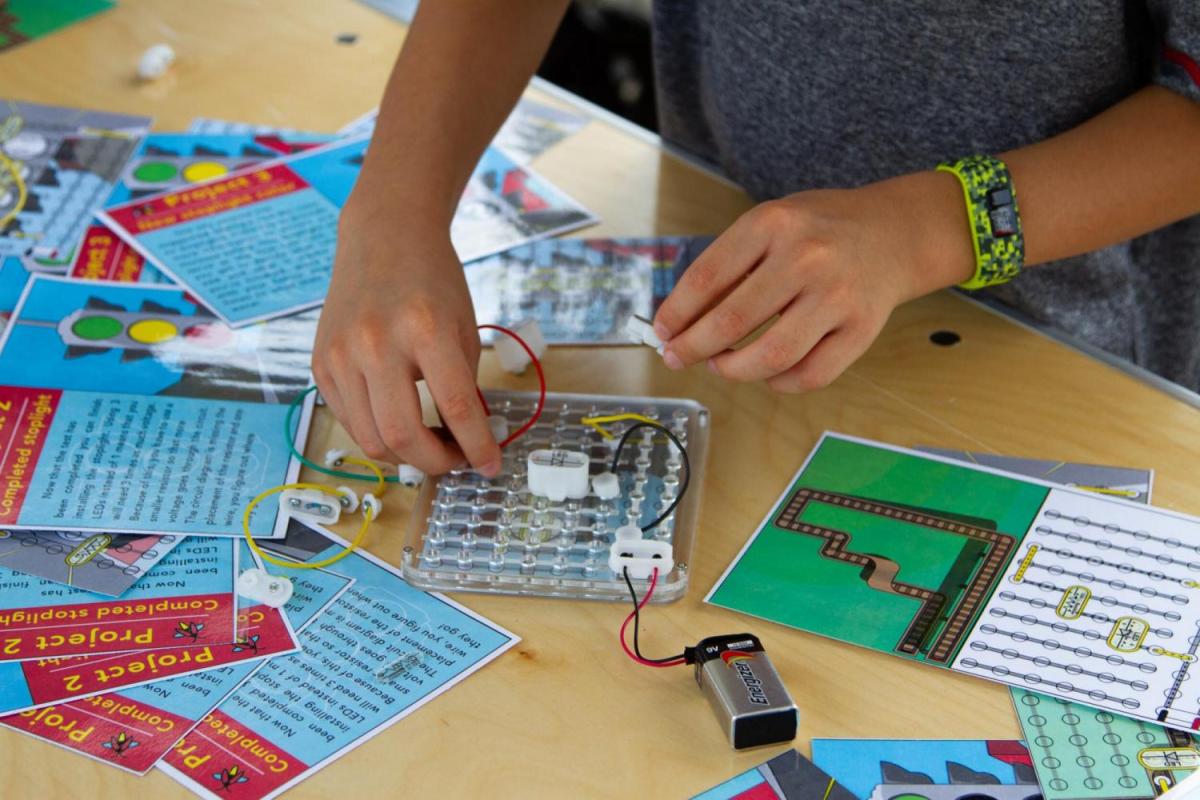 Hands of a person trying an EdBoard with story cards around the board.