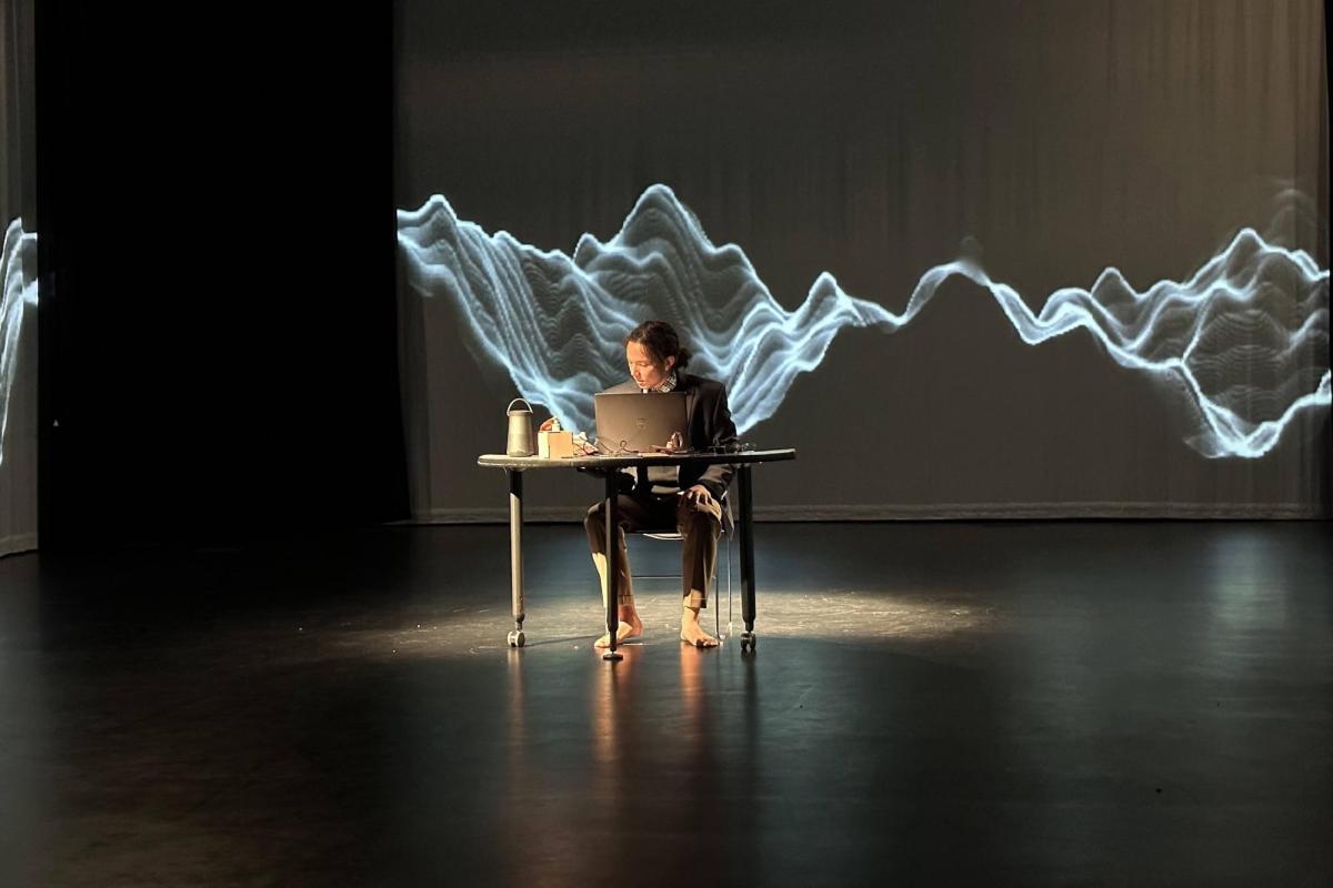 neill sitting at a desk in the middle of the black box