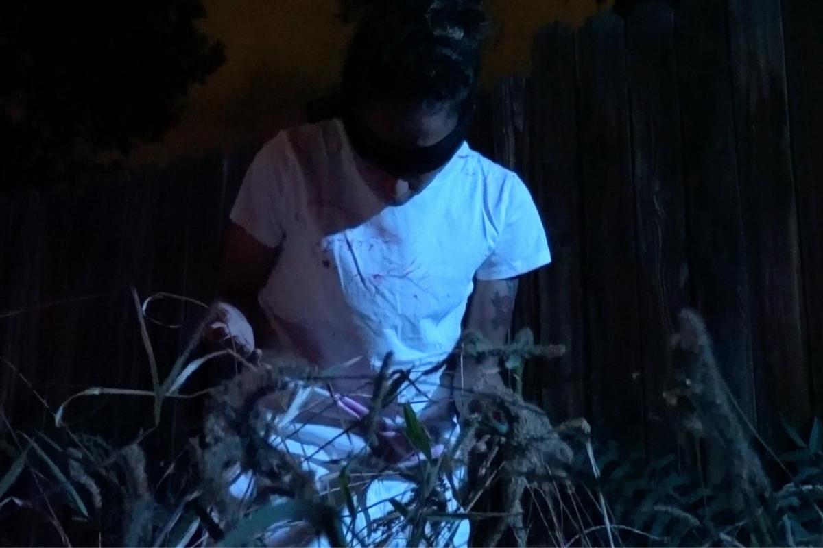 a blind folded person amongst weeds in the night