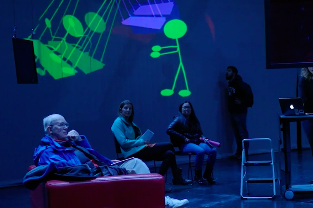 Photo of people in front of screen at "Resonant"