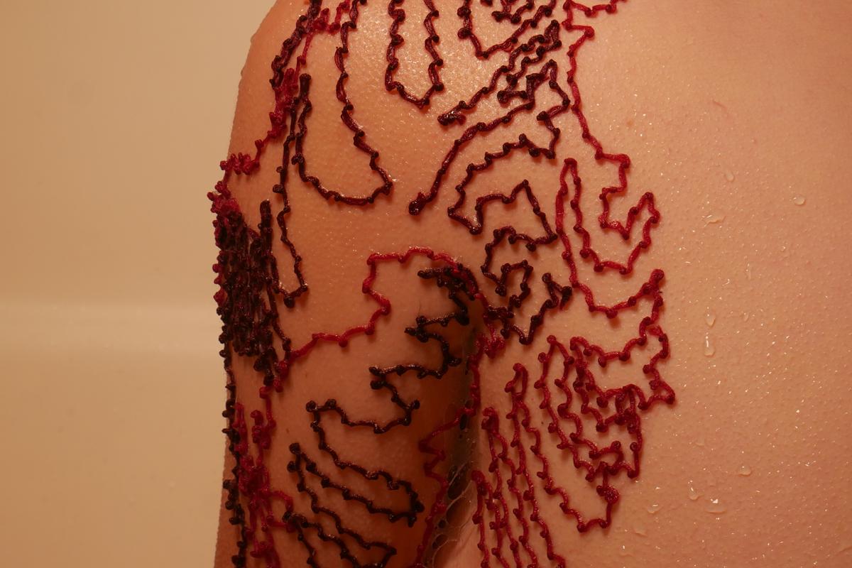 a close up of a shoulder ensnared by a jagged linear red contour
