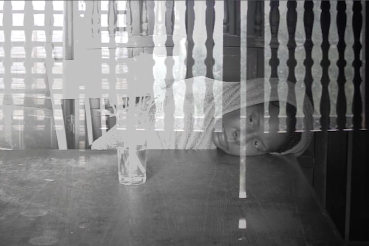 ghostly figure hunched over a table