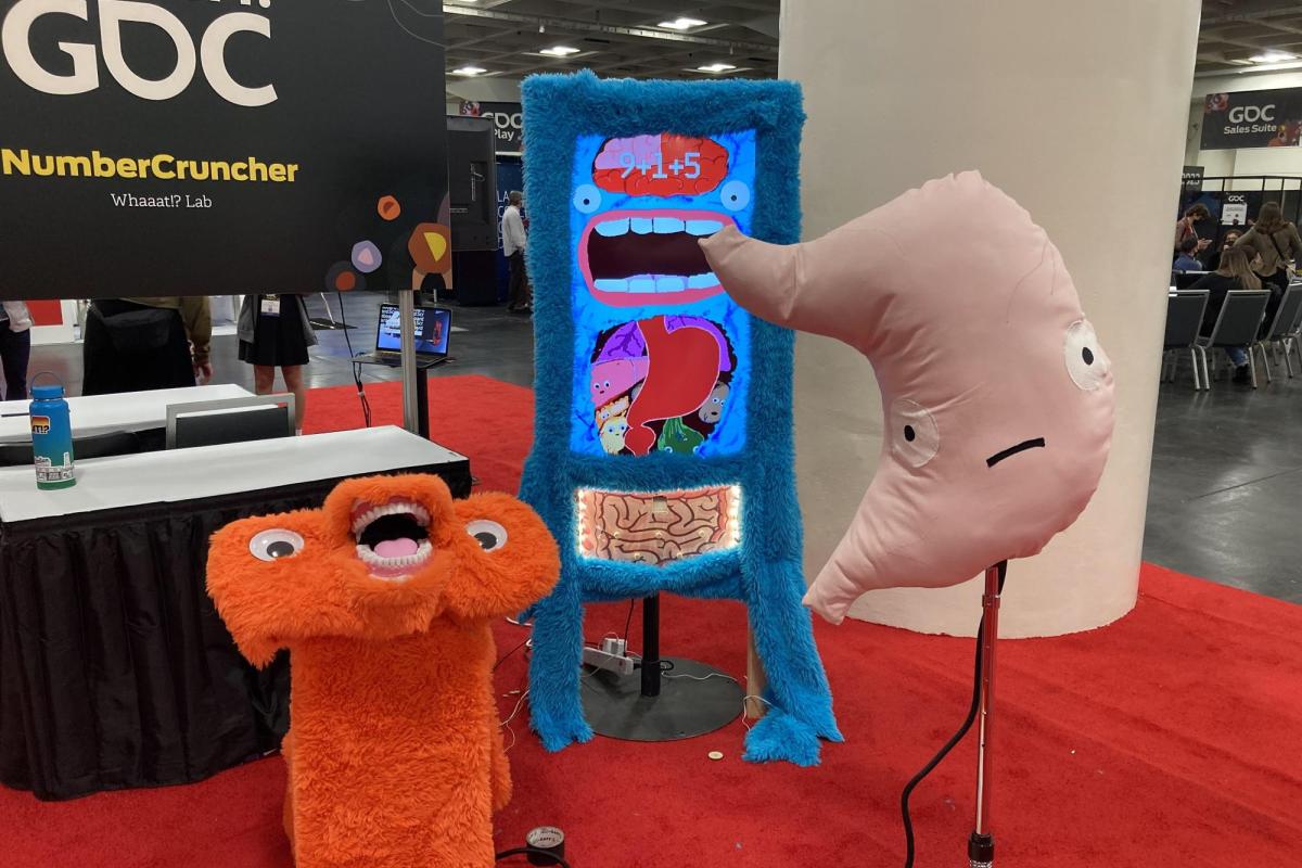 a furry screen, giant stuffed stomach, and an orange furry podium with teeth