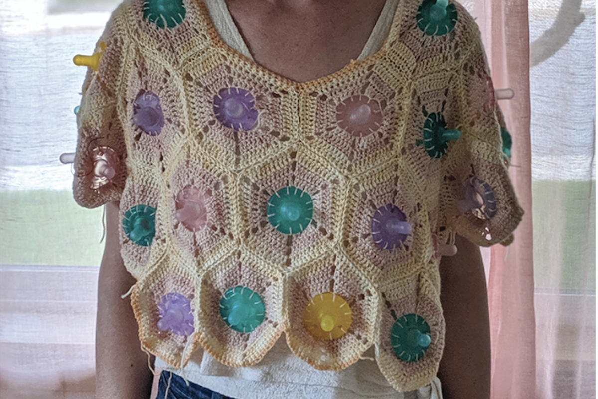 Laura Devendorf wearing a sweater she created with pacifiers attached.