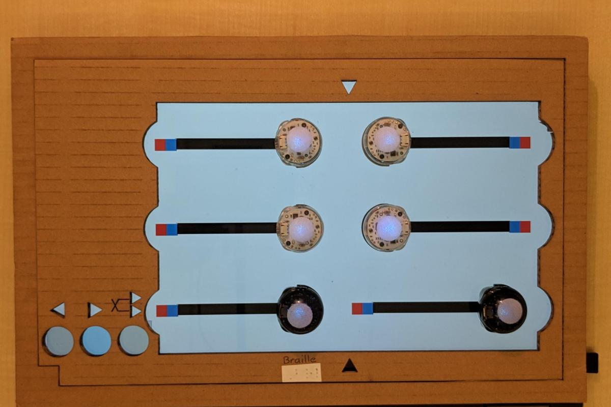 In the Braille Assistant app, mobile robots form a large, tactile version of the letter “Q” (⠟) in Braille.