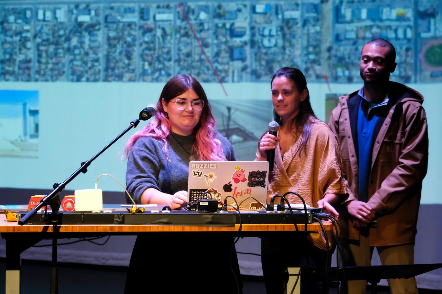 students present at a podium with a projection of a map of Little Saigon behind