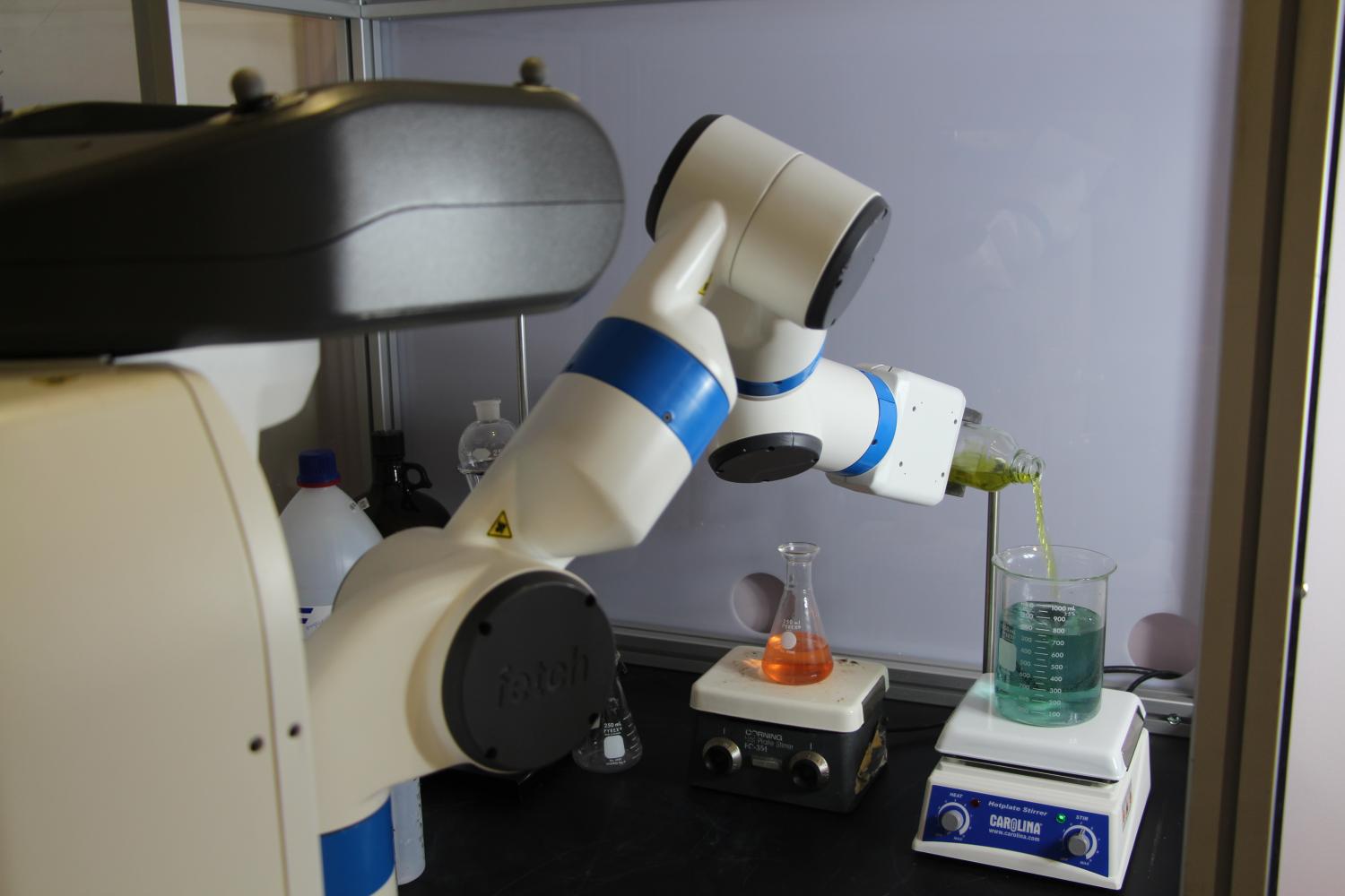 Robochemistry robotic arm pouring liquid from one beaker into another