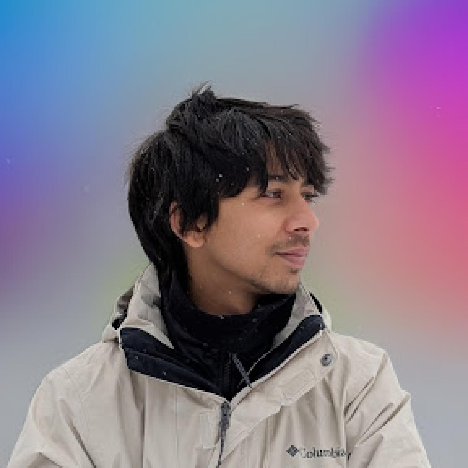 Yash standing in profile with a colorful background