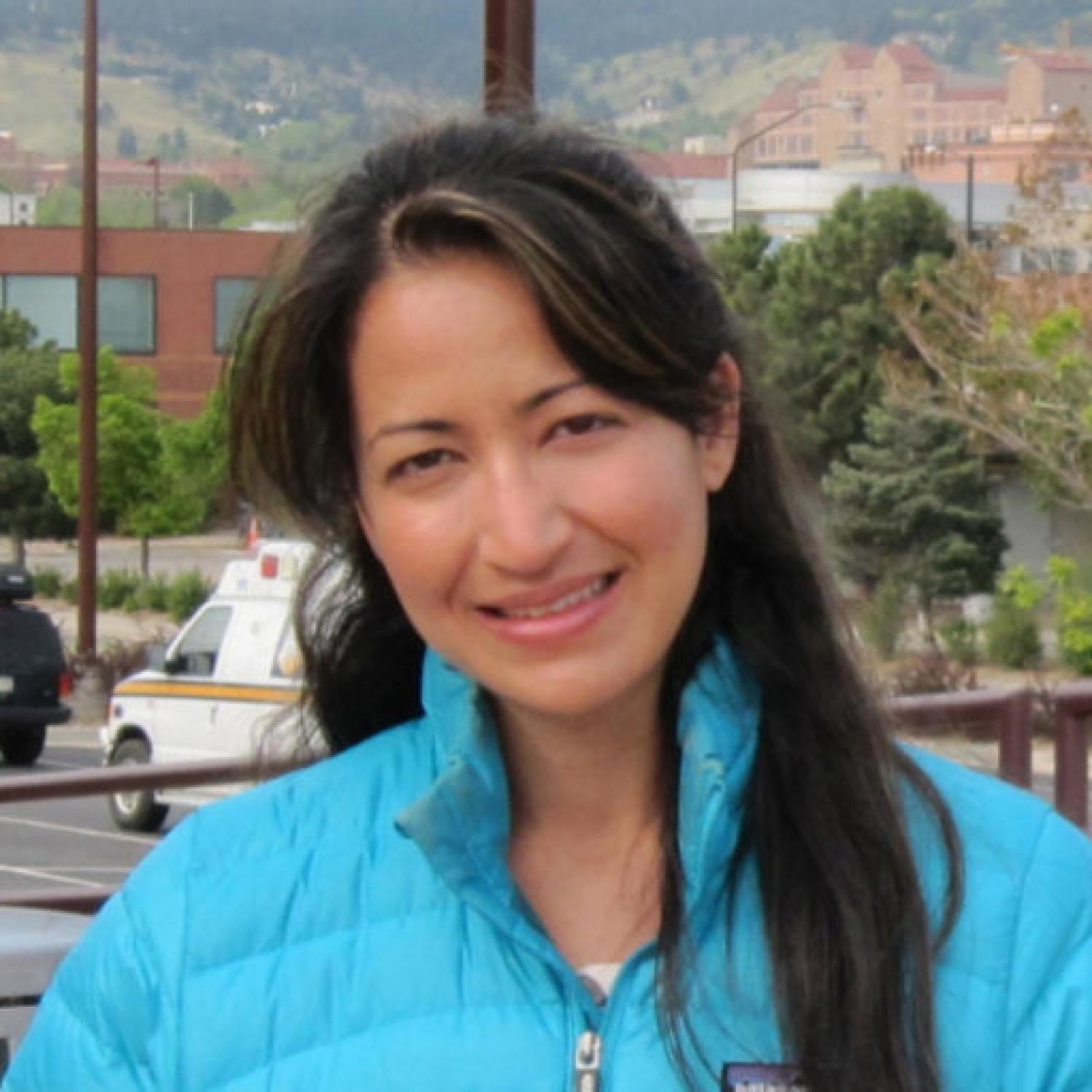 Profile of a woman with long black hair, smiling.