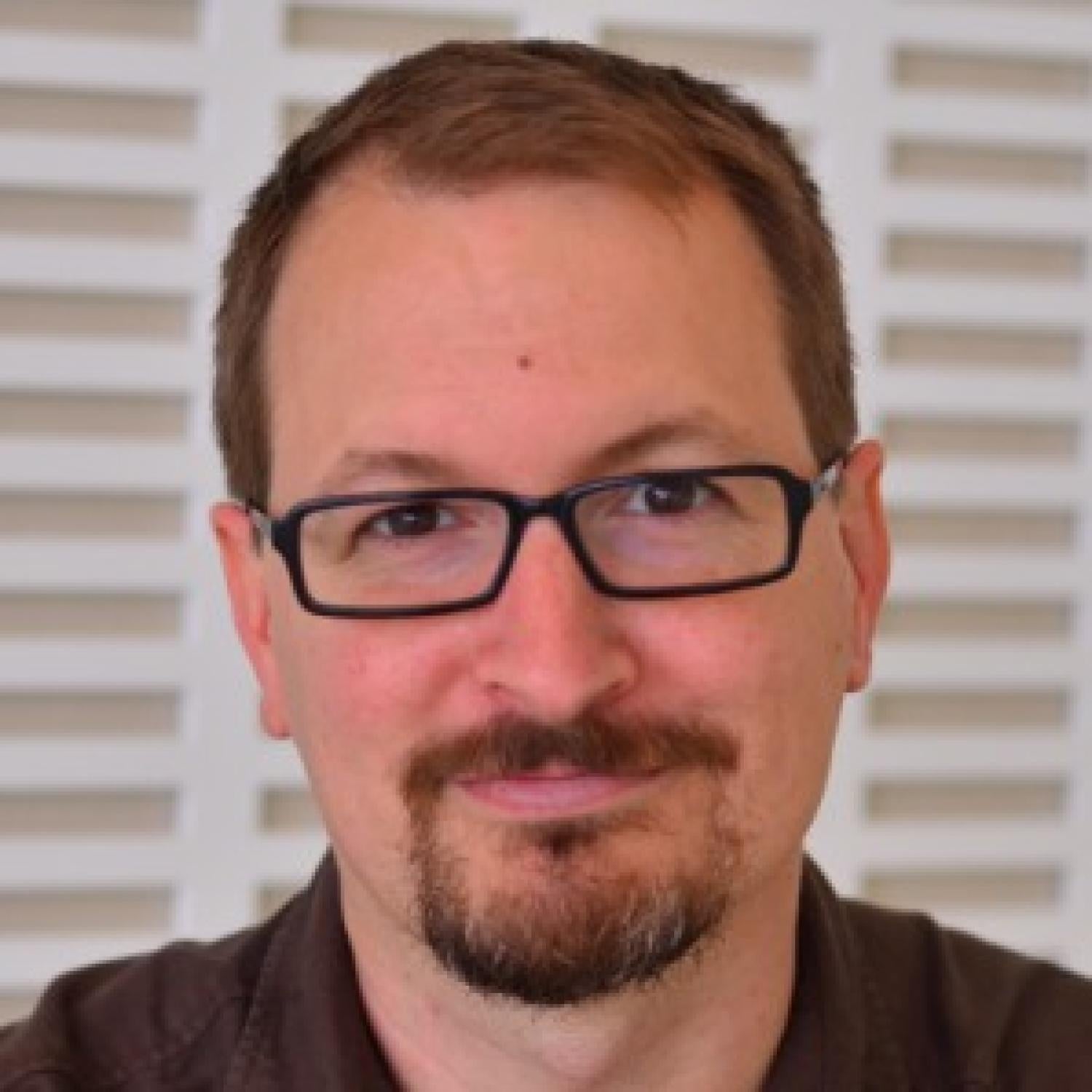 Profile image of an older white man with short brown hair and beard wearing glasses