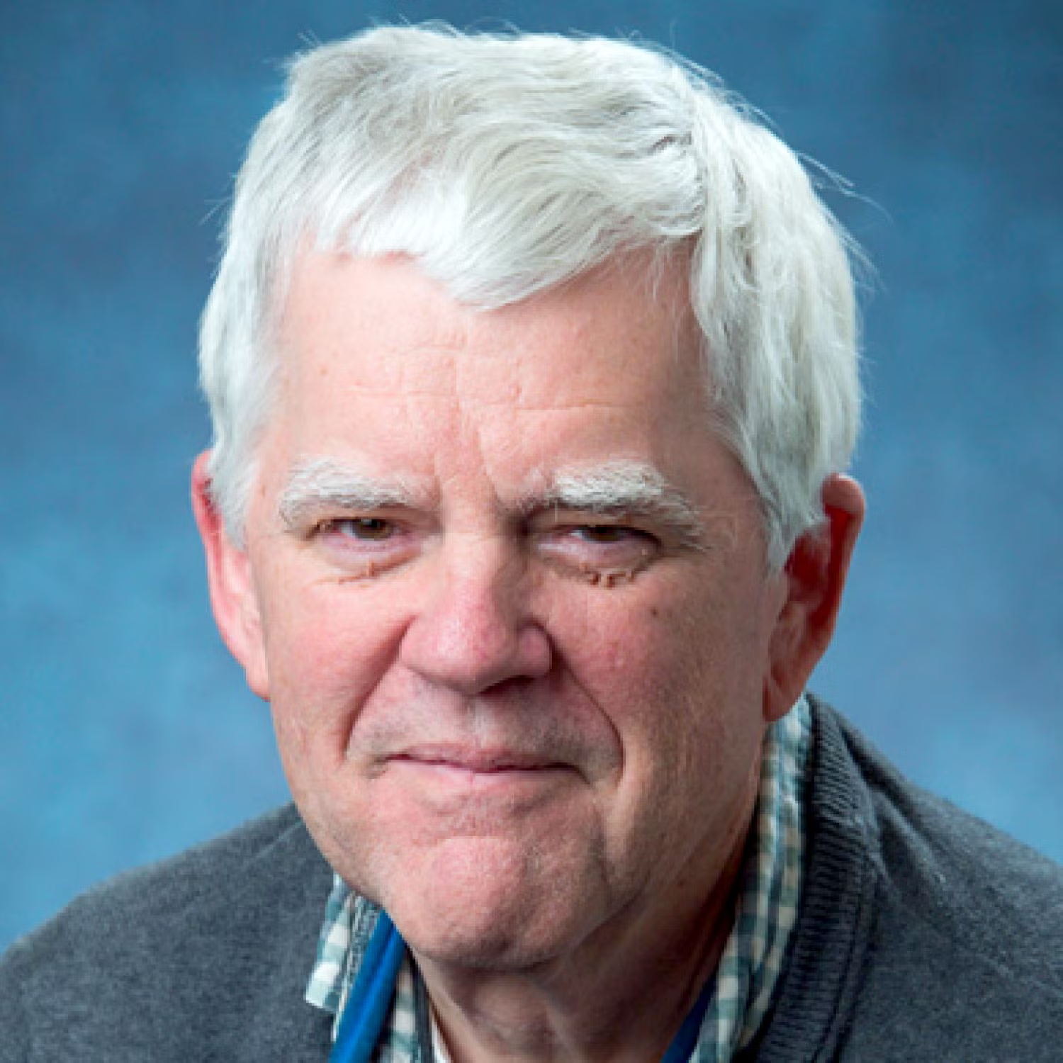 Profile of an old white man with short white hair, smiling.